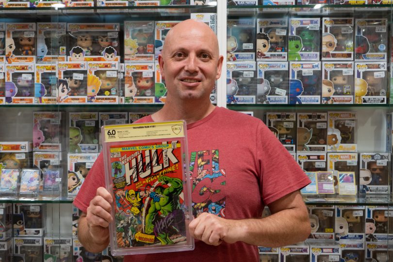 James Penney holding a Stan Lee-signed copy of a Hulk comic book in his store