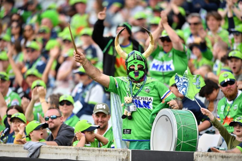 Canberra Raiders fan at game beating drum