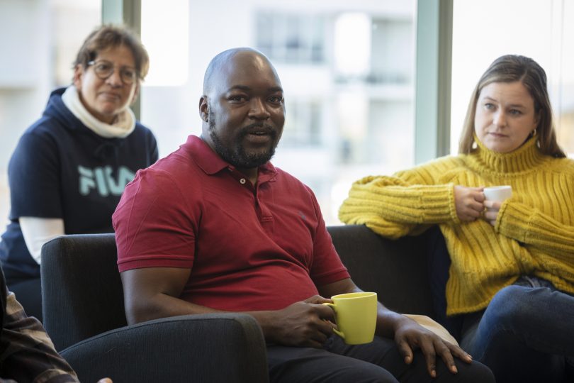 Alfred Chidembo sitting with two women