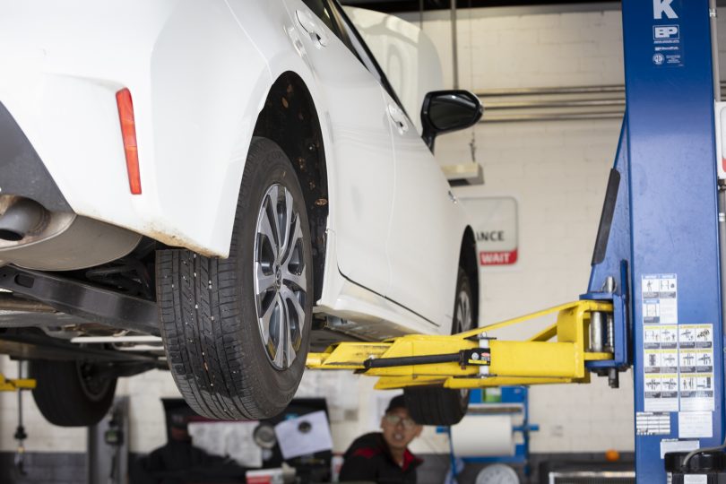 Car on hoist being serviced at workshop