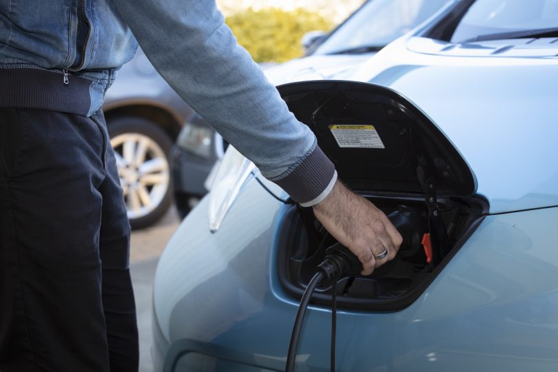 Man charging an electric vehicle