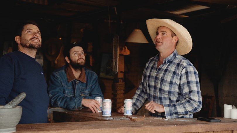 Three men drinking beer and looking upwards