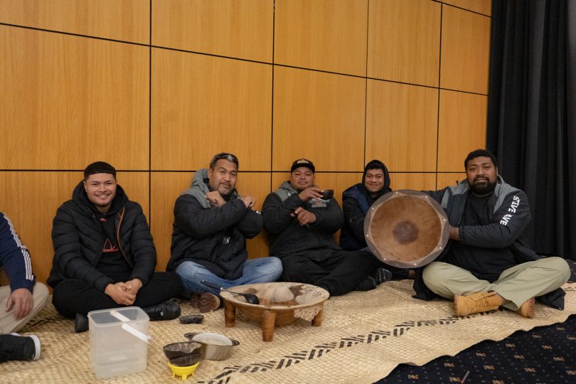 Pacific Islander men sitting on floor drinking kava