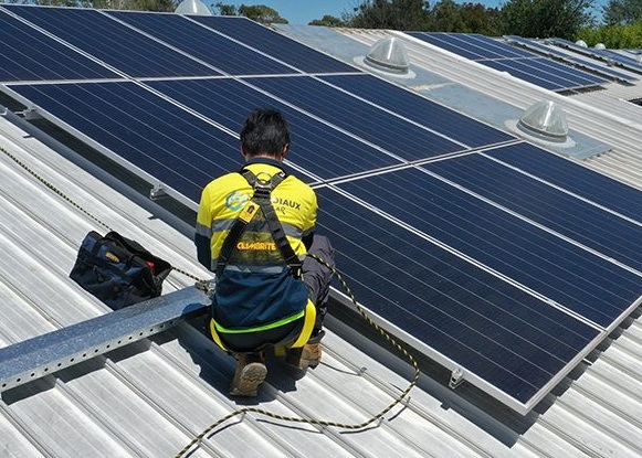 Man installing solar panels on roof