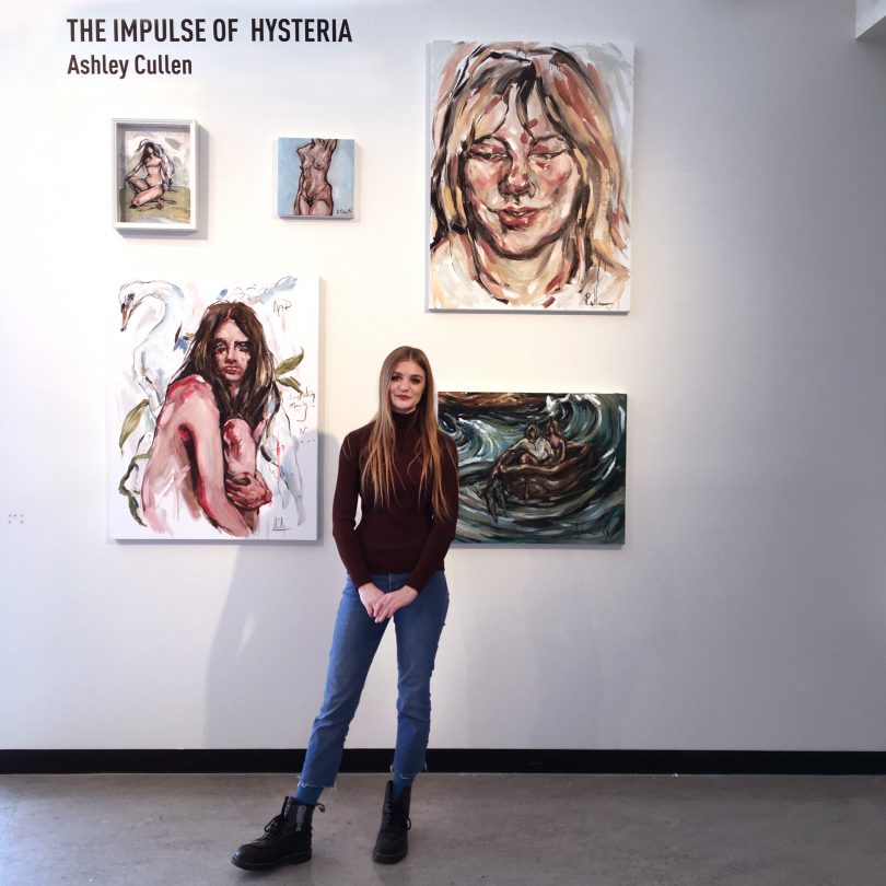 Ashley Cullen standing in front of artwork