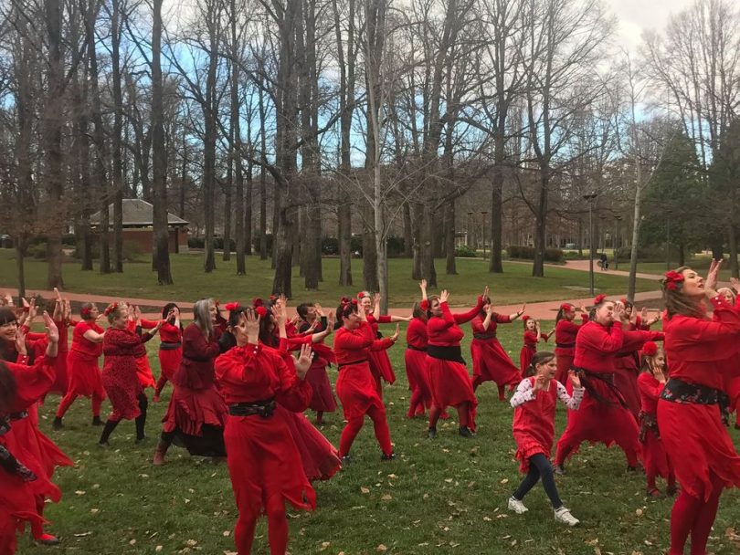 women in red dancing in a park