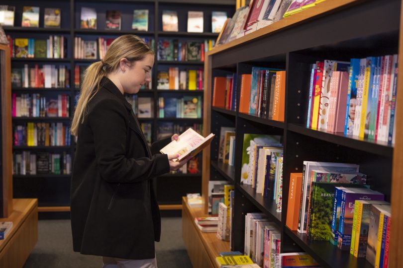 Woman reading book in store