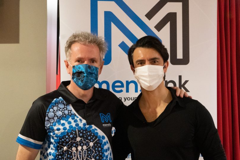 Marty Fisk and Nathan Spiteri wearing masks in front of Menslink banner