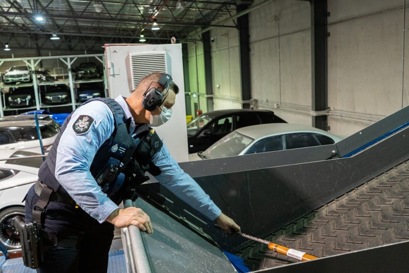 Police officer shredding a seized firearm