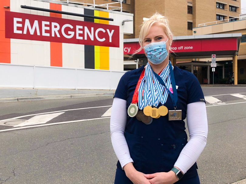 Kathryn Ross outside Canberra Hospital emergency department wearing medals around her neck