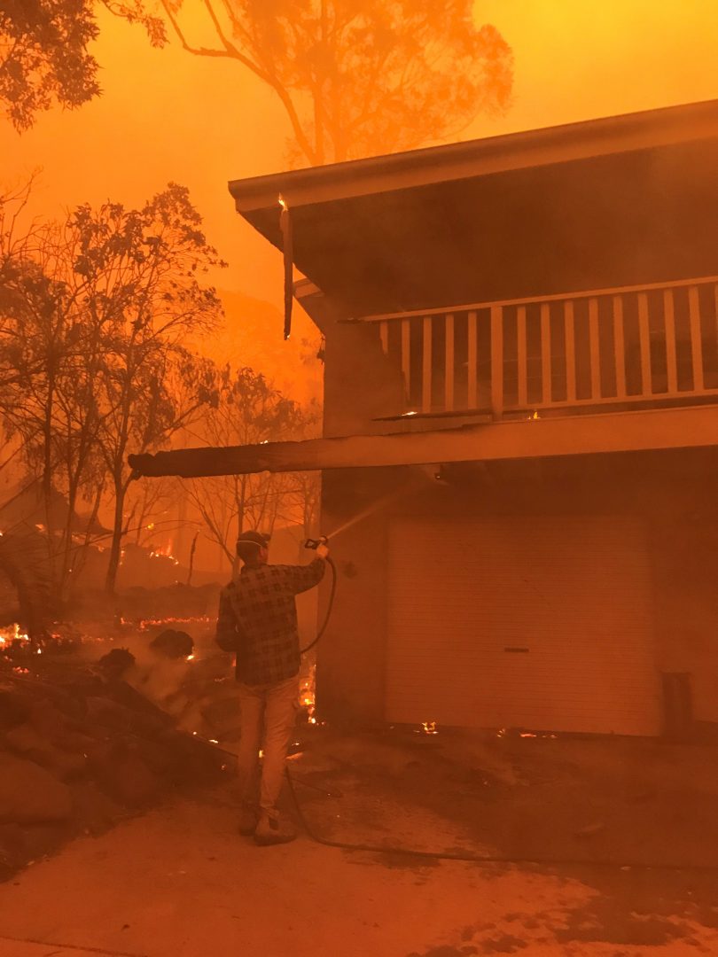 Man with hose fighting house 