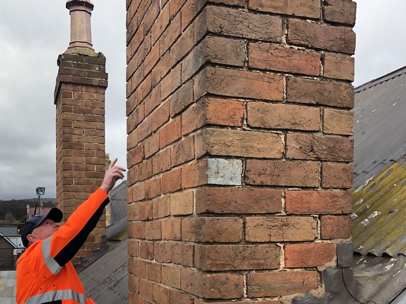 Owen Carragher on roof of St Clair inspecting brickwork