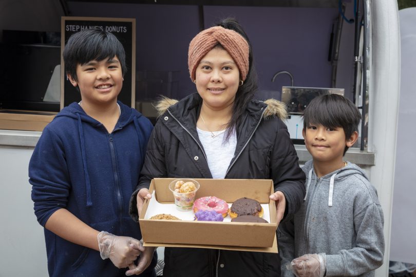 Stephanie with her sons, holding box of assorted donuts