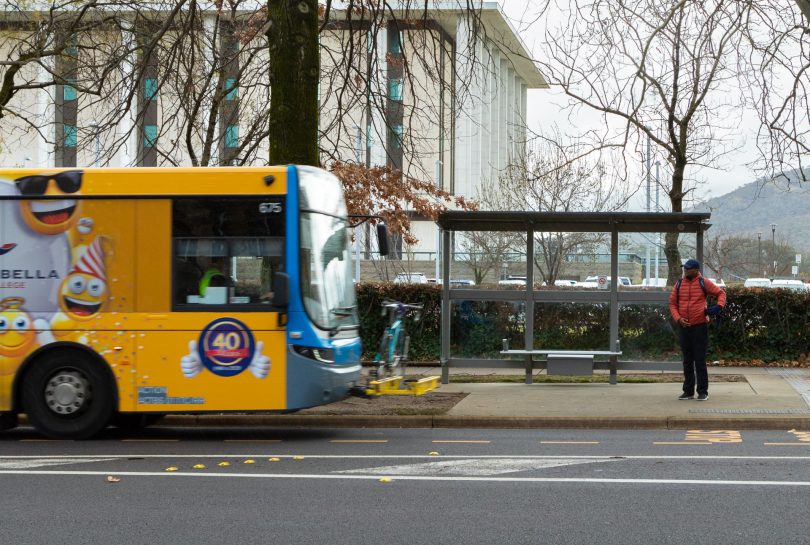 Passenger waiting at bus stop.