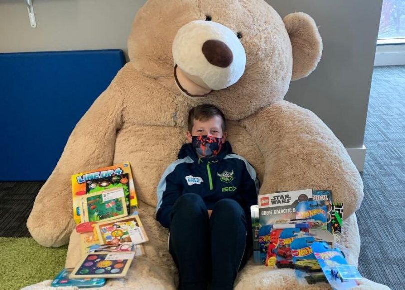 Charlie Brown sitting in a big teddy bear surrounded by gifts