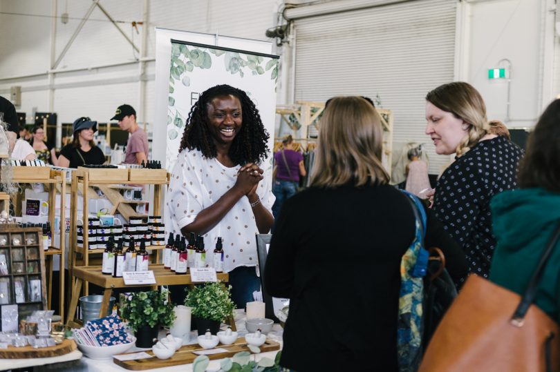 market stallholder laughing talking to customers at the handmade markets