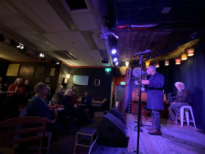Man reciting poetry onstage at Smith's Alternative