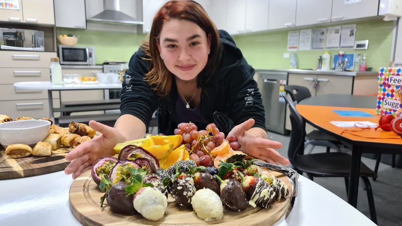 Girl showing off food prepared in hospitality class