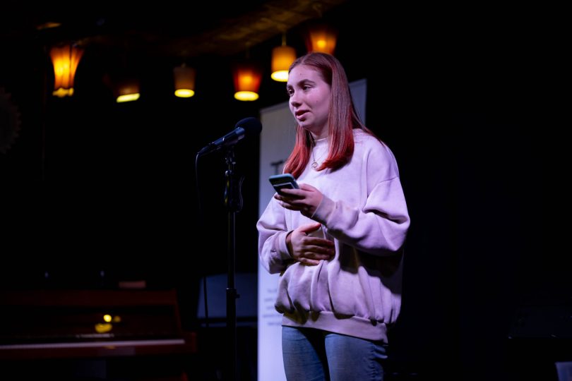 Girl reciting poetry onstage at Smith's Alternative