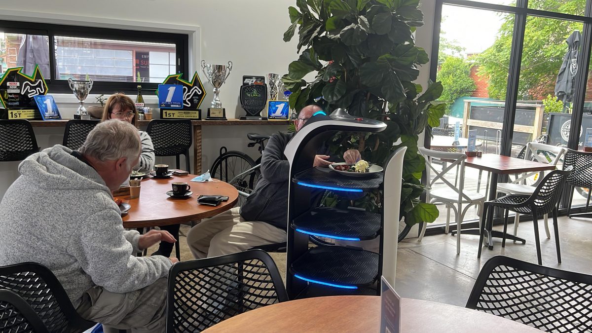 Customers putting plates on robot waiter