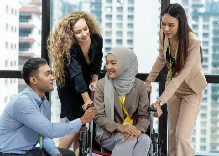 People standing around a woman in a wheel chair