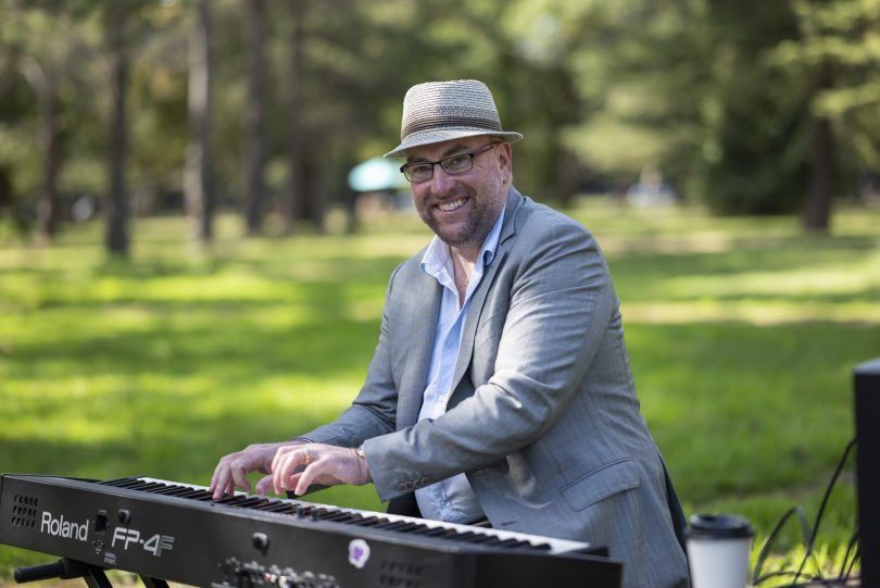 Wayne Kelly playing music on keyboard in park