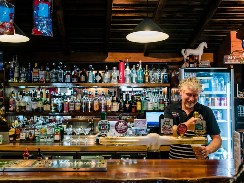 man pouring beers at pub