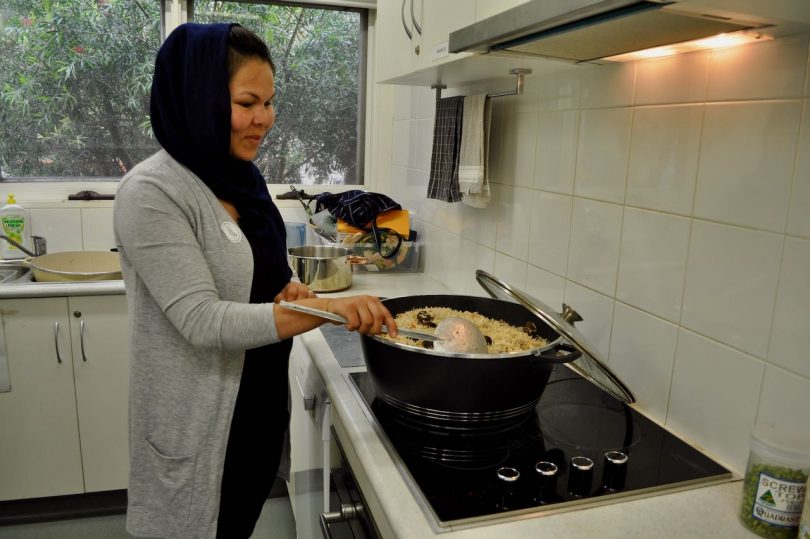Woman in hijab making a rice dish