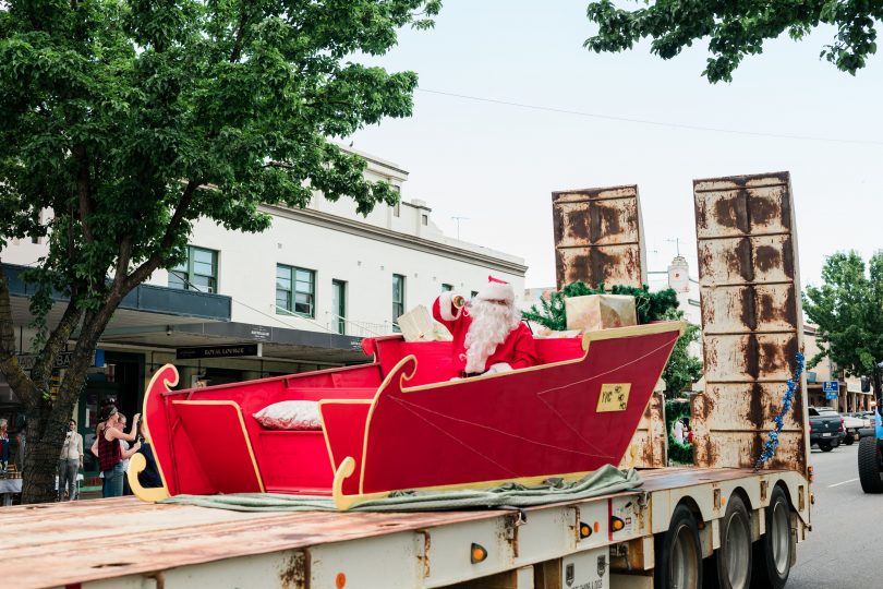 Santa in sleigh on back of flatbed truck