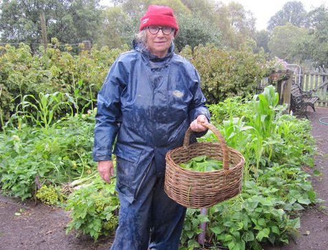 Bronwyn Richards standing in garden in wet-weather gardening clothes