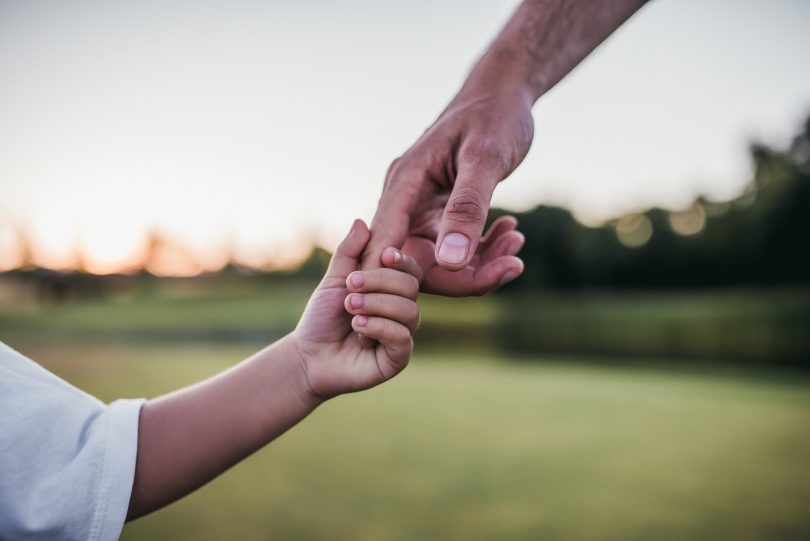 Dad and son holding hands