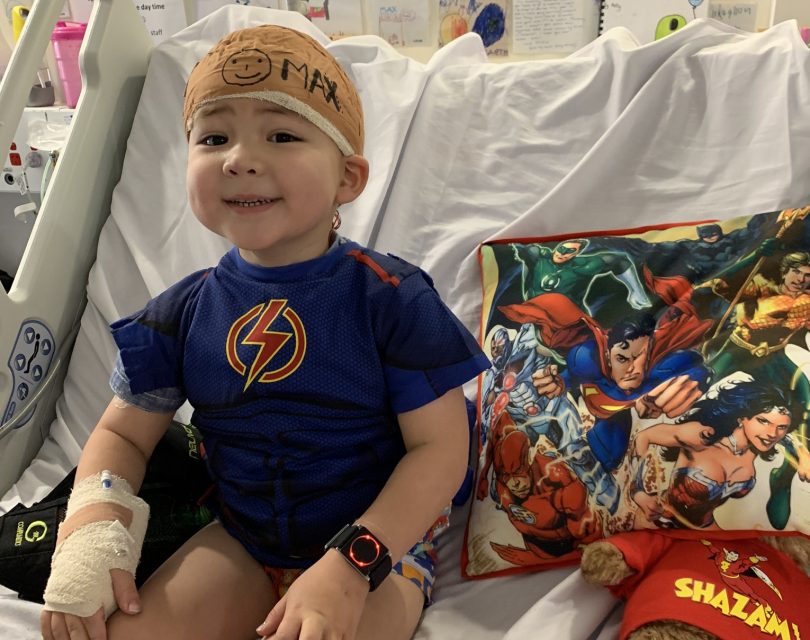 A boy on a hospital bed with his head wrapped in bandages