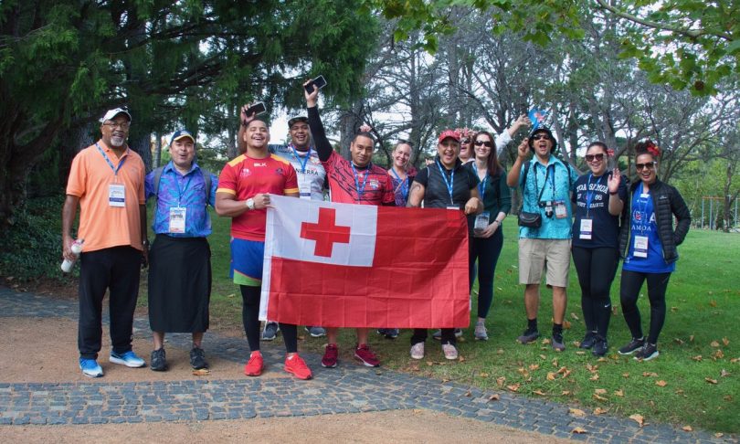 group of people holding Tonga flag