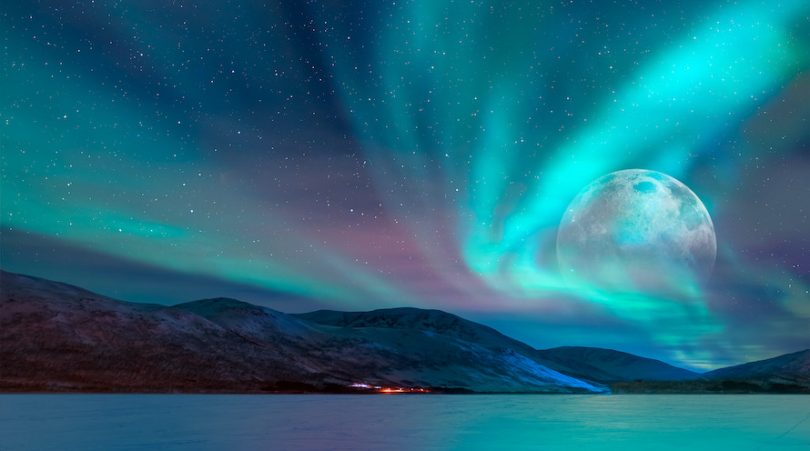 the night sky with Northern Lights and moon in the background