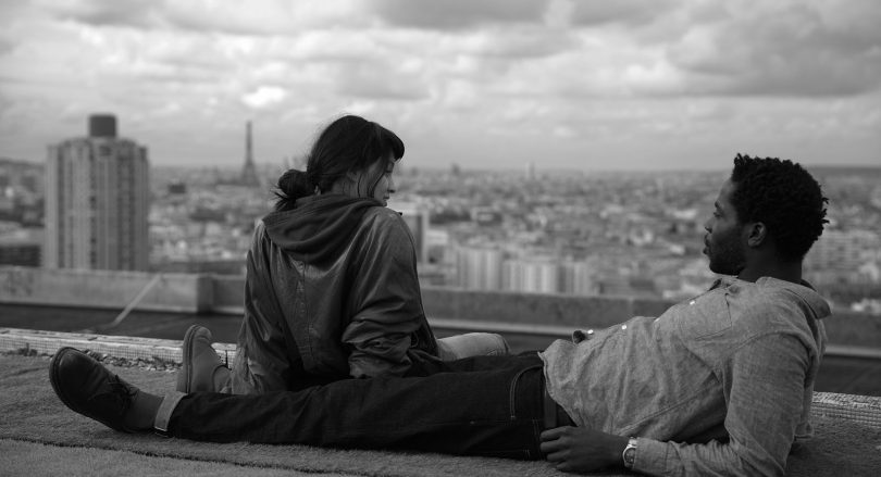 Woman and man sitting on edge of roof