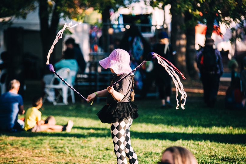 Child twirling ribbon sticks