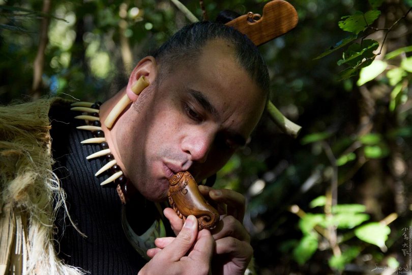 Man in traditional dress playing musical instrument