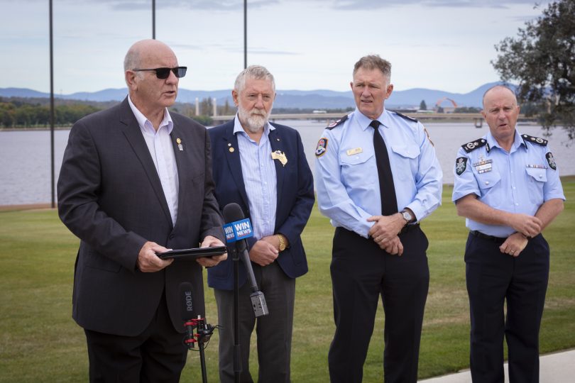 Two men in suits and two policemen