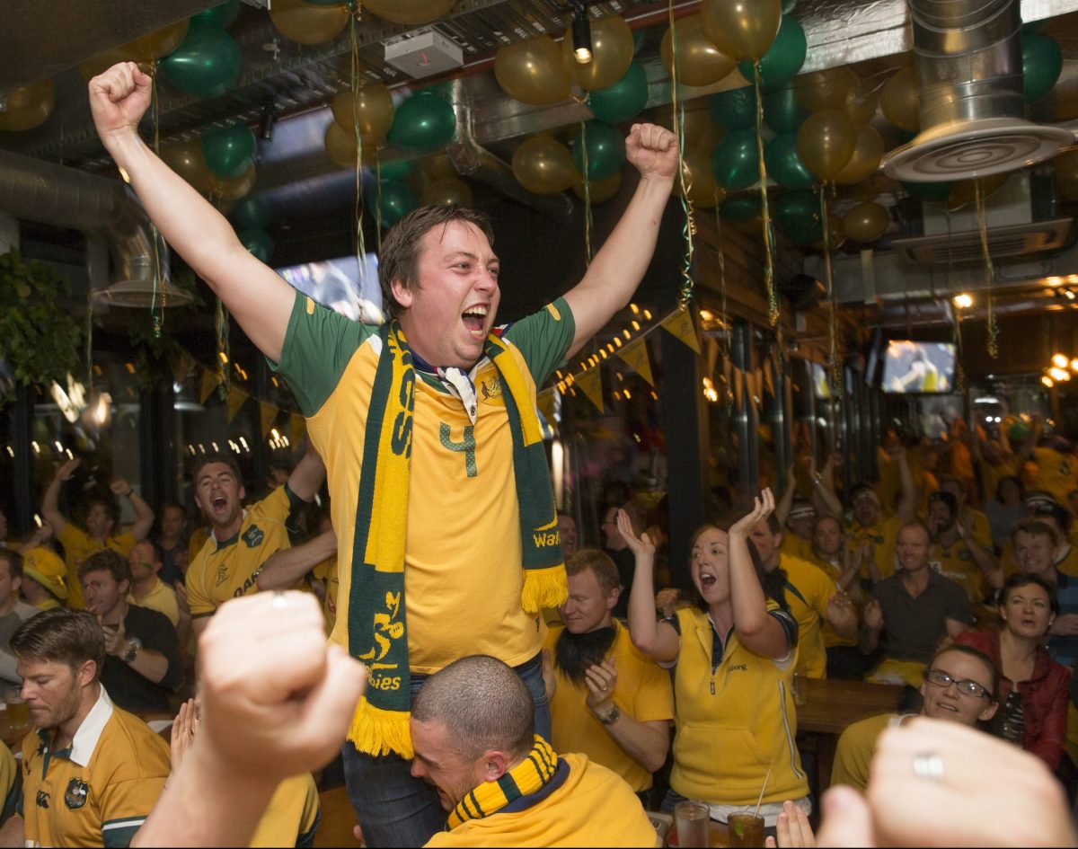 a man cheering wearing yellow and green