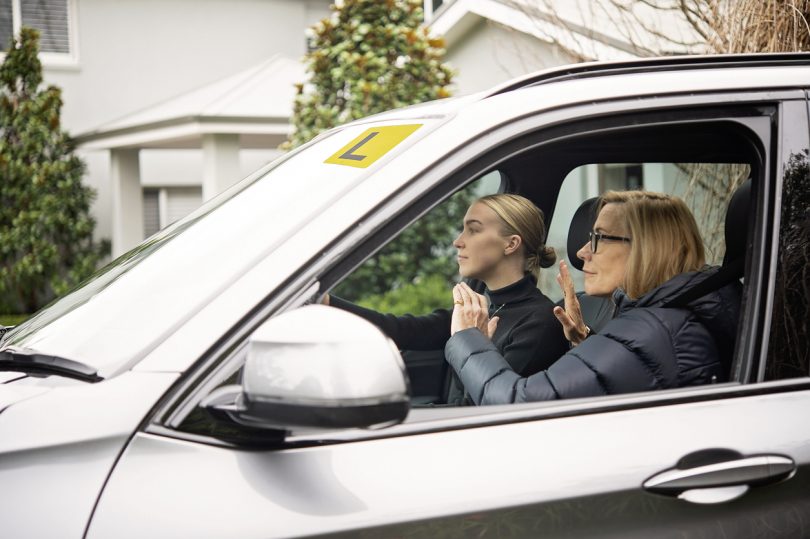 Driving instructor and learner driver in car