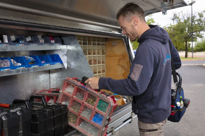 person picking up toolboxes from a truck