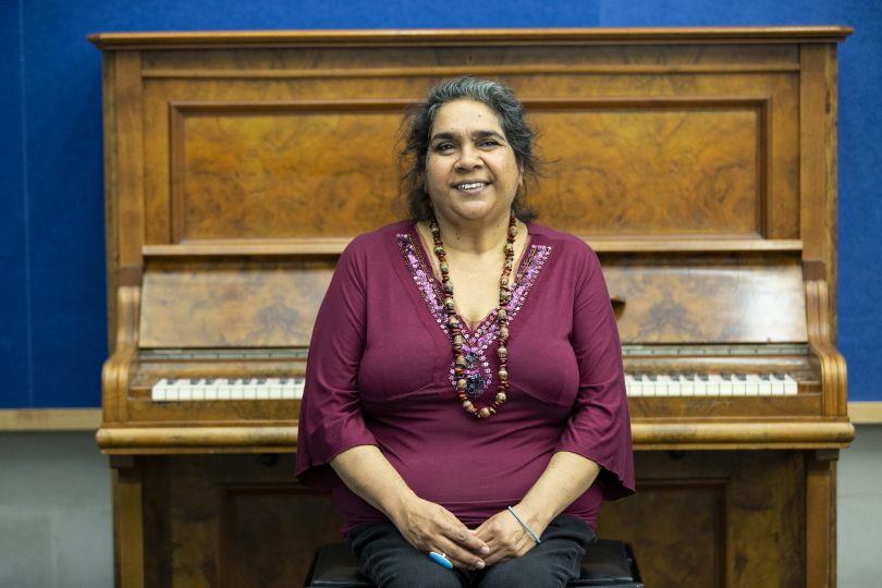 Woman sitting in front of a piano