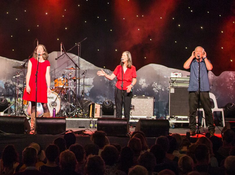 Three performers on stage