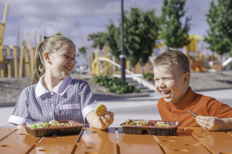 two kids eating Smiley's lunch boxes