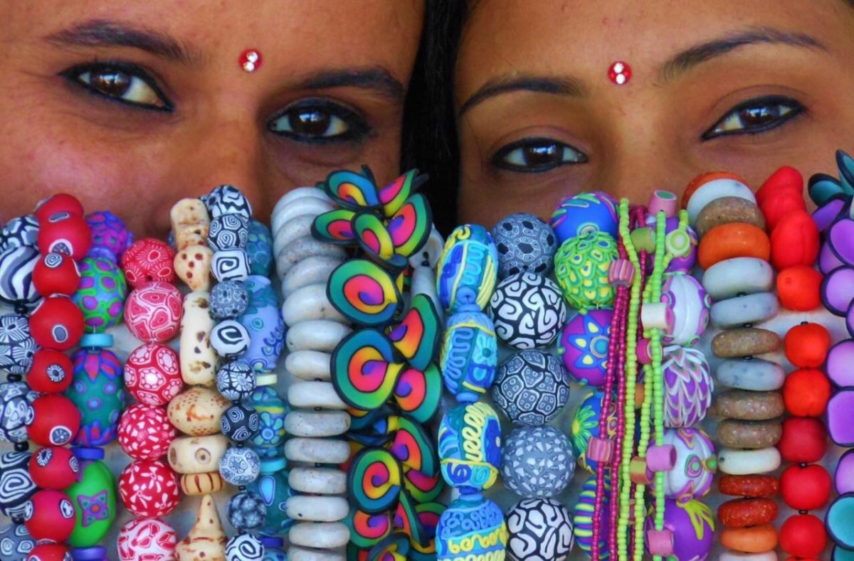 two people with colourful beads in front of their faces