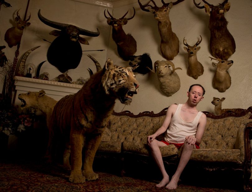 Man sitting in front of taxidermy animals