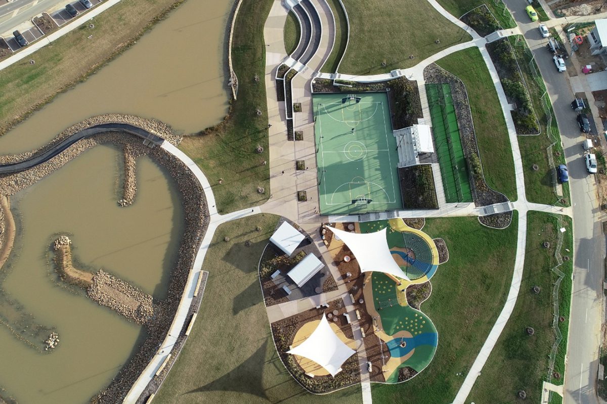 Aerial view of suburb with lake and sporting facilities.