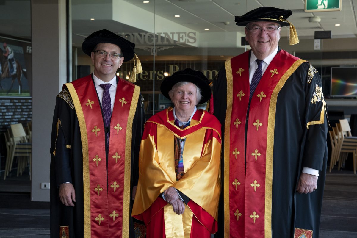 Two men and a woman in graduation garb