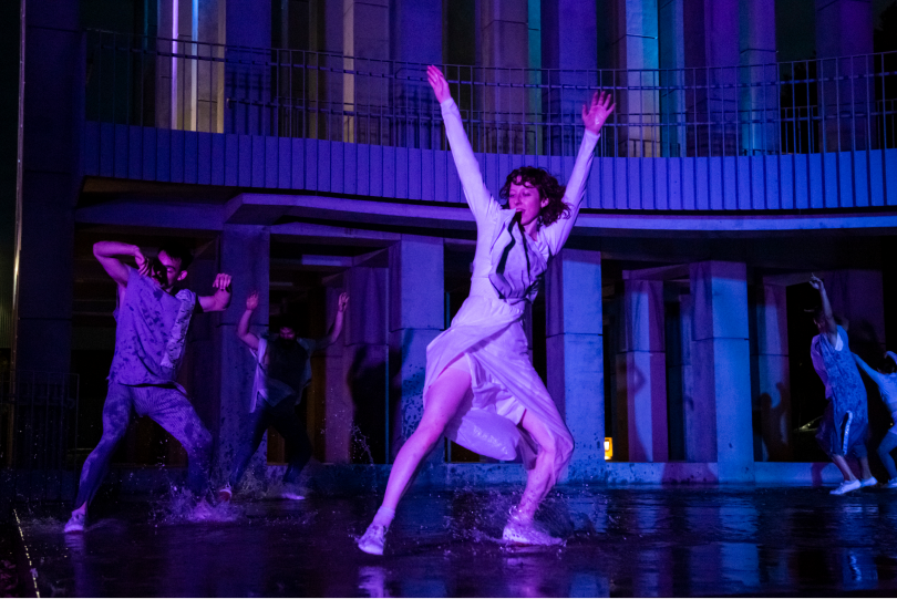 dancer on stage with their hands up