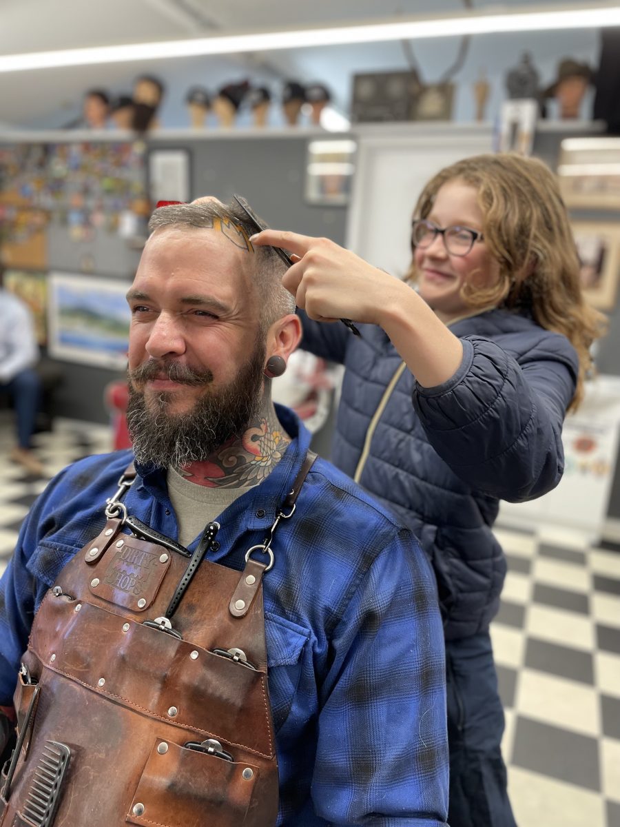 Matilda Edwards styles father Dave's hair.